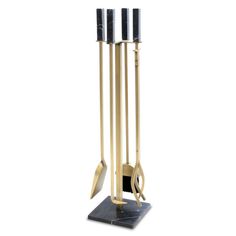 a gold and black metal sculpture with four candles on it's base, standing upright in front of a white background