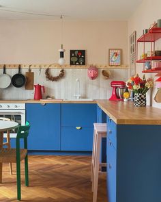 a kitchen filled with lots of blue cabinets and counter top next to a wooden floor