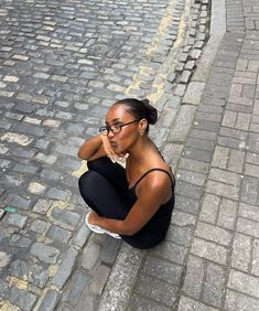 a woman sitting on the ground with her head in her hands