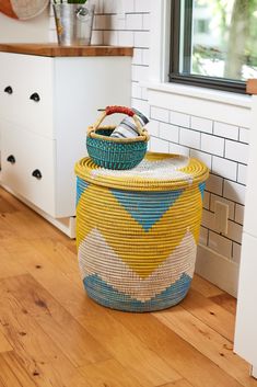 a basket sitting on top of a wooden floor next to a window