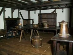 an old fashioned room with wooden floors and tables