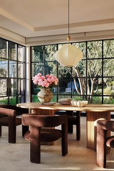 a dining room with large windows and wooden furniture