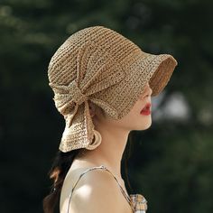 a woman wearing a brown hat with tassels on it's brim