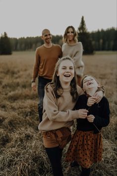 two girls laughing with their parents in the background