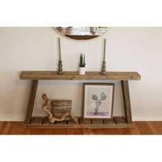 a wooden shelf with candles on it next to a mirror and potted plant in the corner