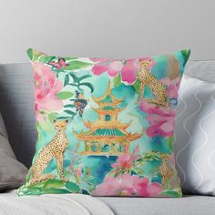 a colorful pillow with leopards and flowers on the front, sitting on a couch