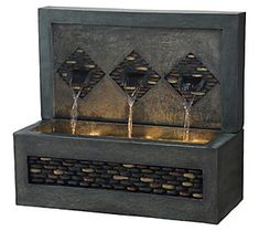 a water fountain with three wine glasses on it's sides and lights at the top