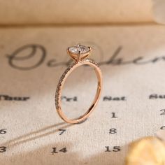 an engagement ring sitting on top of a piece of paper