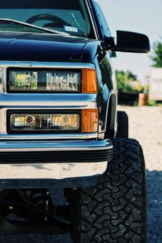 the front end of a pickup truck with its lights on