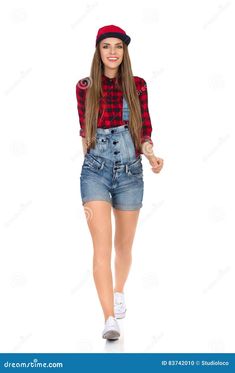 a girl in overalls and plaid shirt is walking