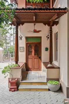 an entrance to a house with wooden doors and pillars