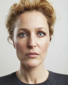 a woman with blonde hair and blue eyes looks at the camera while wearing a black shirt