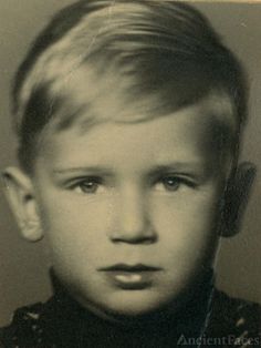 an old black and white photo of a young boy with blonde hair wearing a bow tie