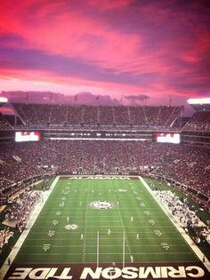 a football stadium filled with lots of people watching the sun go down on it's field