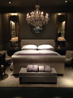 a bedroom with a large bed and chandelier