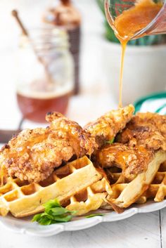 chicken and waffles are being drizzled with sauce on a plate