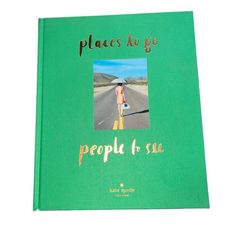 a green book with an image of a woman walking down the road in front of her