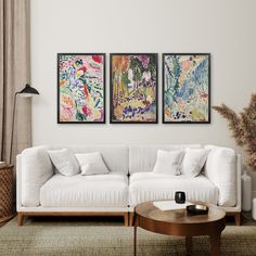 a living room with two paintings on the wall and a coffee table in front of it