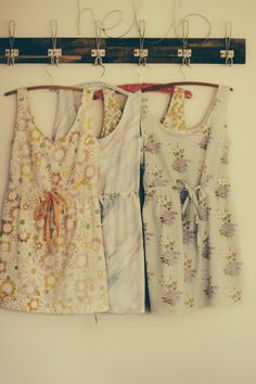 three dresses hanging on a clothes line with pegs