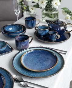 the table is set with blue dishes and silverware