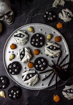 halloween cookies decorated with white icing and spooky eyes are on a plate