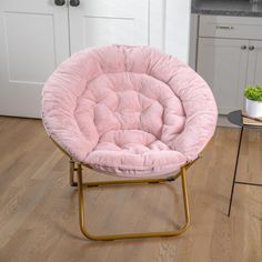 a pink chair sitting on top of a wooden floor