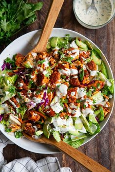 a salad with dressing in a white bowl on a wooden table