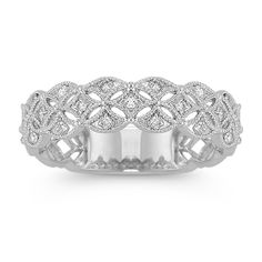 a white gold ring with diamonds on the sides and an intricate design in the middle