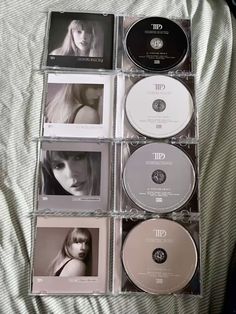 cd's are arranged on a bed with white sheets