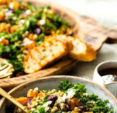 a bowl filled with salad next to bread