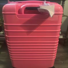 a pink suitcase sitting on top of a wooden floor