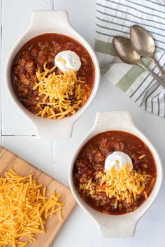 two bowls of chili with cheese and sour cream