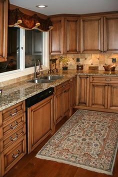 a kitchen with wooden cabinets and an area rug in front of the stove top oven