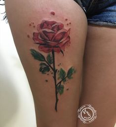 a woman's thigh with a rose tattoo on it