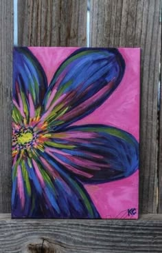 a painting of a purple flower on a pink and blue background by a wooden fence