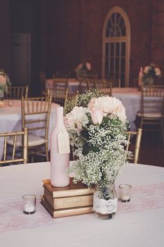 a vase with flowers and baby's breath sits on a table