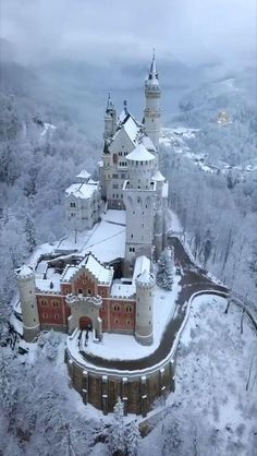 an aerial view of a castle in germany with snow on the ground and trees around it