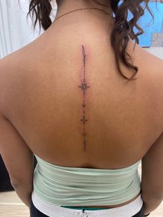 a woman with a cross tattoo on her back