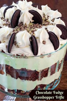 an oreo cookie trifle dessert in a glass dish with whipped cream and chocolate cookies