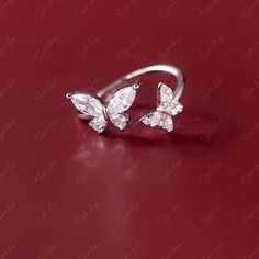 Capture the hearts of your loved ones with this stunning 925 sterling silver ring adorned with sparkling cubic zirconia gemstones in the shape of two delicate butterflies. Its open band design allows for easy adjustment to fit any finger size. Whether given as a gift or worn as an everyday accessory, this ring is sure to make a dazzling statement. Adjustable up to size US 6.Material: 925 sterling silver, cubic zirconiaFinish: platinum plate Jewelry Care: See more information about how to care fo Adjustable Butterfly Ring With Cubic Zirconia, Adjustable Cubic Zirconia Butterfly Ring For Wedding, Adjustable Cubic Zirconia Butterfly Wedding Ring, Cubic Zirconia Open Butterfly Ring For Anniversary, Diamond White Cubic Zirconia Butterfly Promise Ring, Adjustable Cubic Zirconia Butterfly Open Ring, Cubic Zirconia Butterfly Open Ring For Promise, Cubic Zirconia Open Butterfly Ring For Promise, Cubic Zirconia Butterfly Ring For Wedding