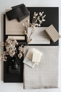 various items are arranged on a black and white tablecloth, including soaps, napkins, and flowers