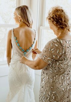 two women standing in front of a window