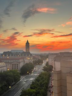 the sun is setting over a city with tall buildings