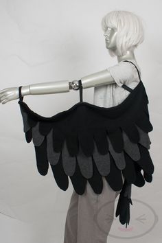 a mannequin with black feathers on it's arms