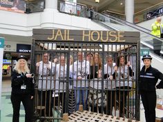 a group of people standing in front of a jail cell