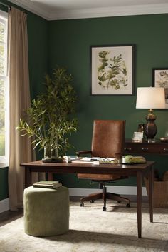 an office with green walls and furniture in the corner, along with a large window