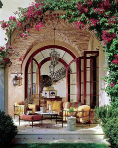 a living room with lots of furniture and flowers on the wall above it's doorway