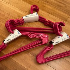 three pieces of red plastic sitting on top of a wooden floor