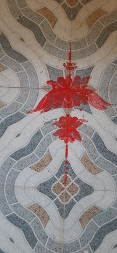 an artistic tile design with red paint on the top and bottom, as well as two birds