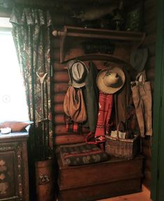 there are many hats and coats hanging on the wall in this room, along with other items